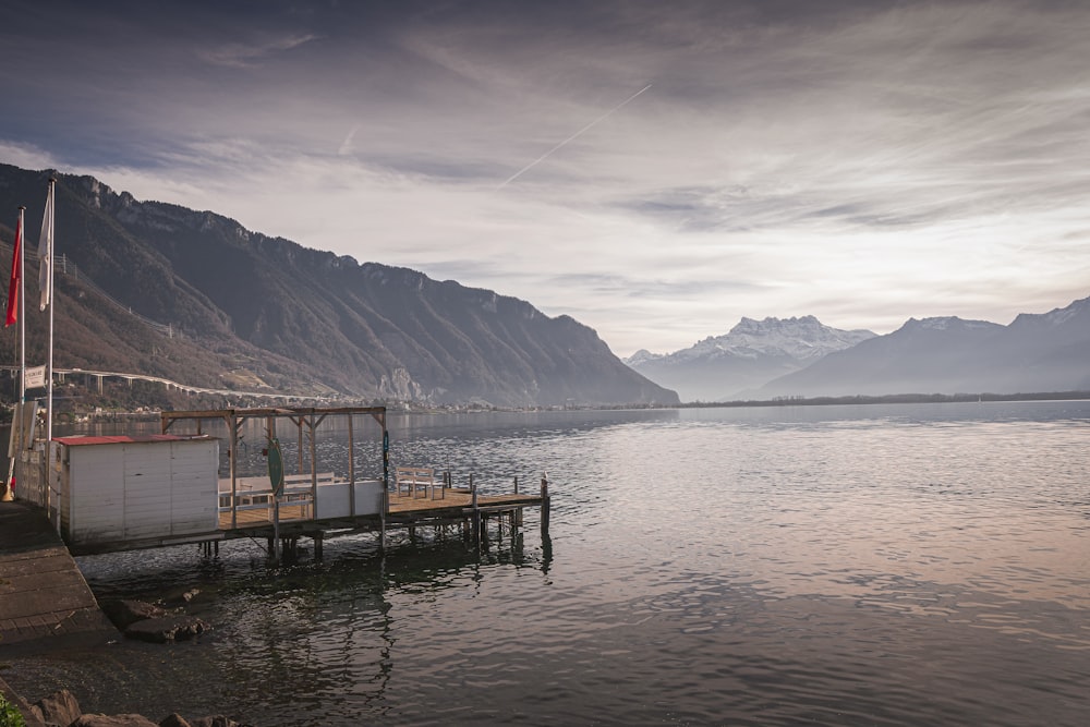 a boat dock on a lake with mountains in the background