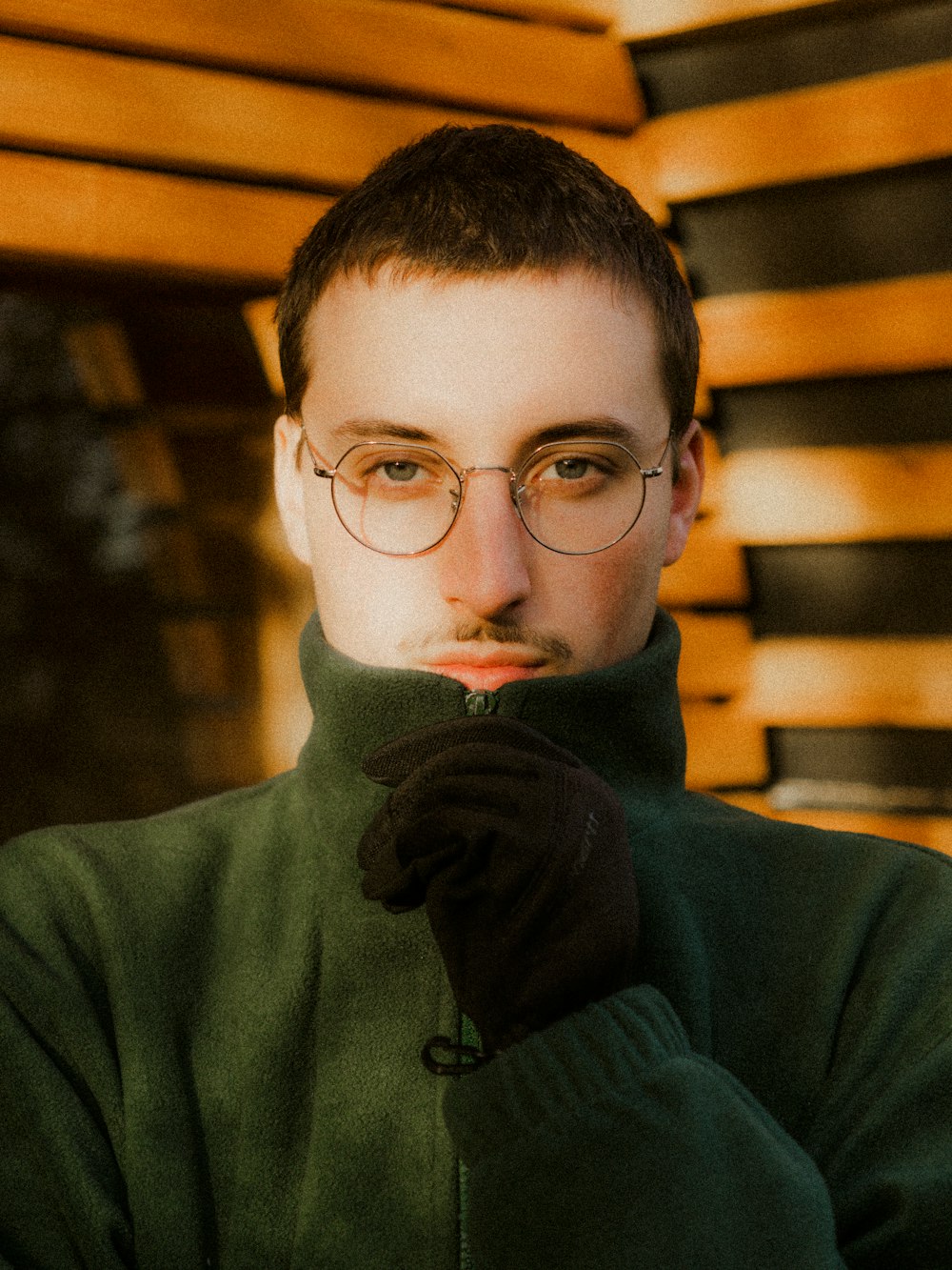 a man wearing glasses and a green jacket