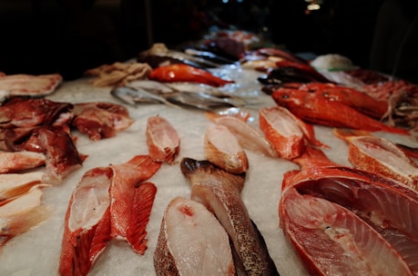 Assortment of fresh fish and seafood displayed on ice at a wholesale market.