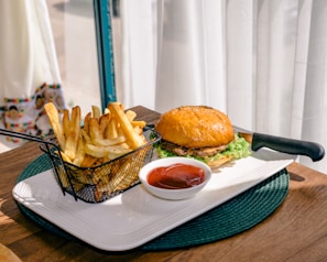 Colorful plates with hamburgers, hot dogs, and sides on a vibrant table.