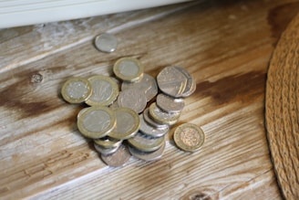 A close-up of dinar coins on a wooden table.