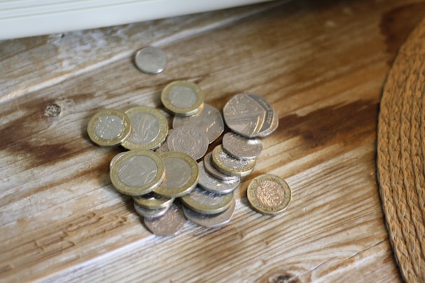 A close-up of dinar coins on a wooden table.
