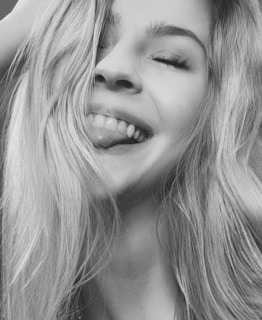 a black and white photo of a woman smiling