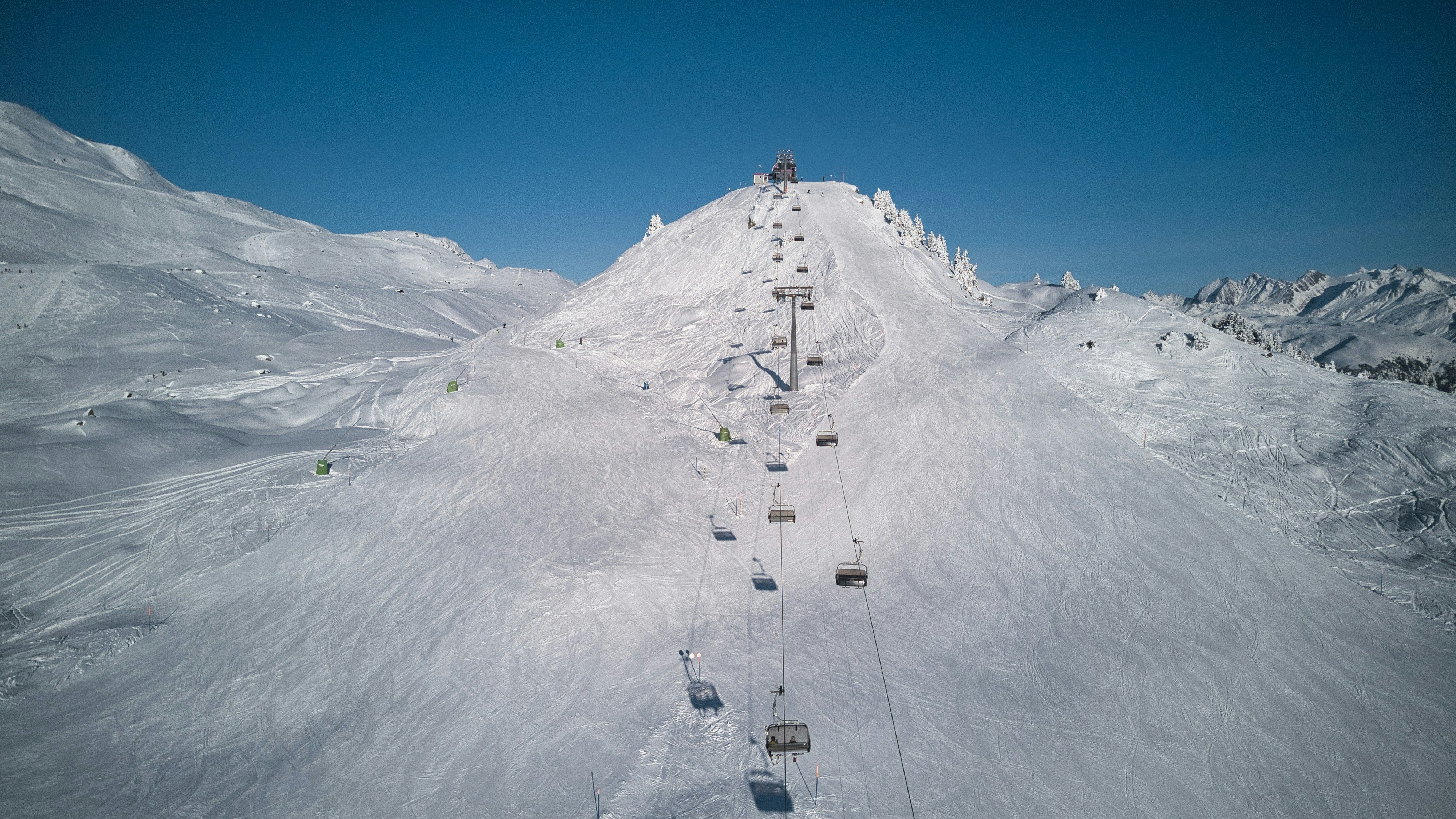 a ski lift going up the side of a snow covered mountain