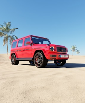 A red SUV is parked on a sandy beach with clear blue skies. Two palm trees are visible in the background, creating a tropical atmosphere. The vehicle's modern design is highlighted by its sleek body and shiny wheels.