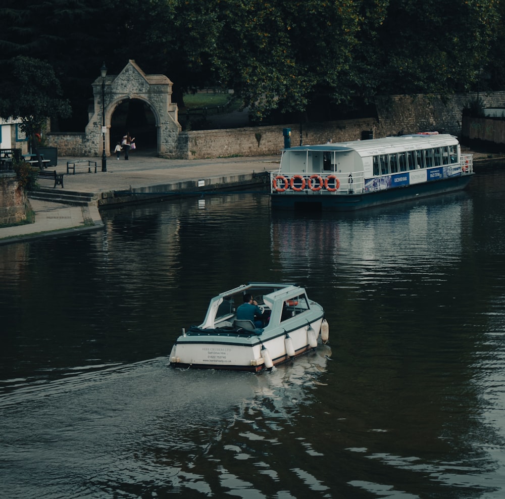 a boat traveling down a river next to a bridge