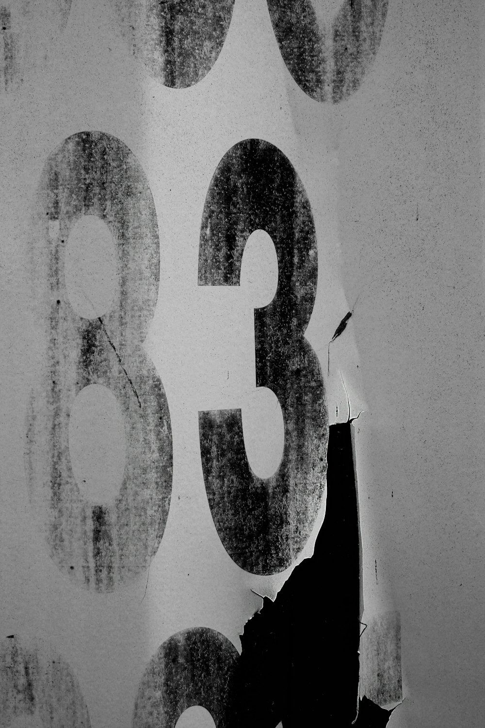 a black and white photo of a person writing numbers on a wall