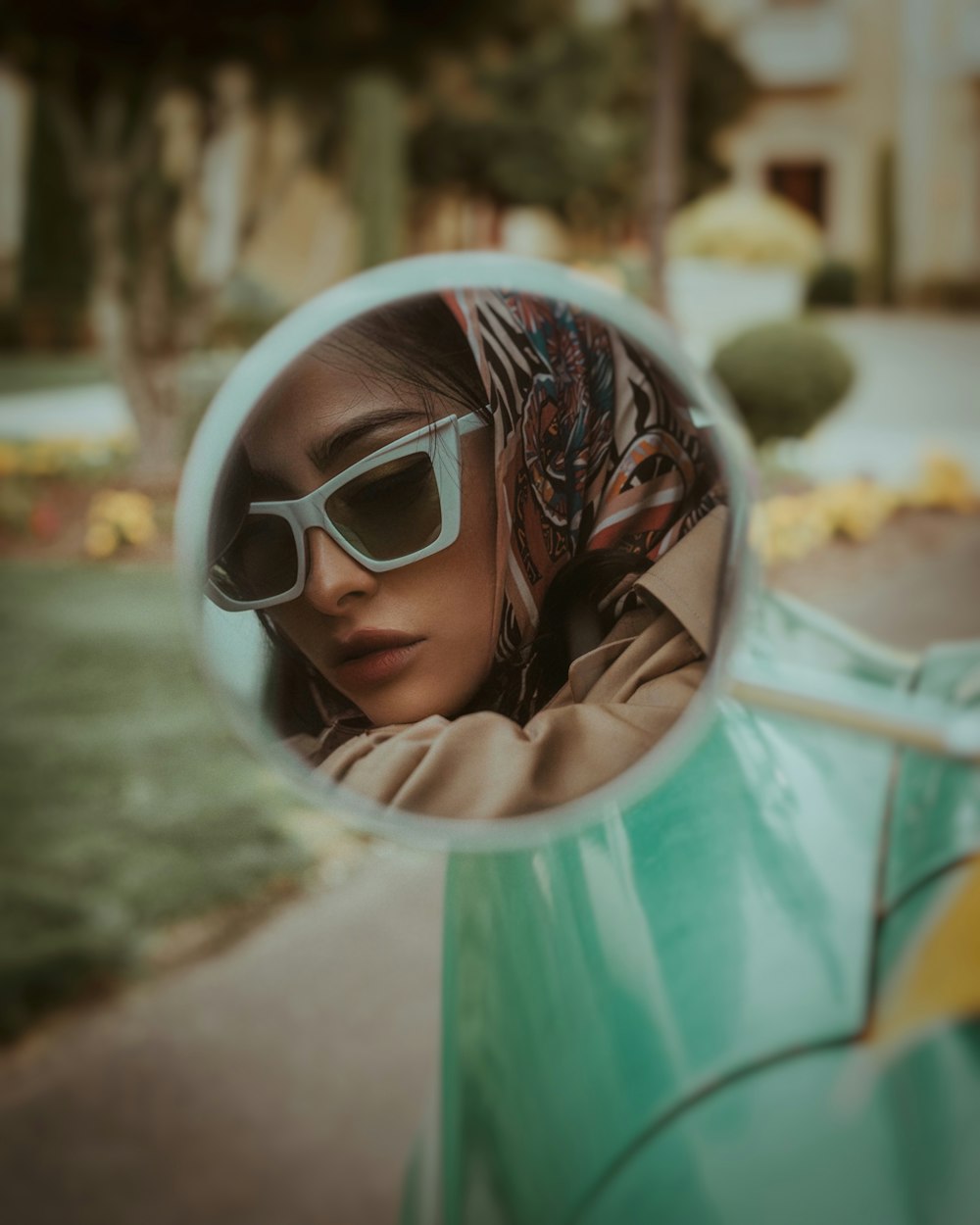 a woman wearing sunglasses is reflected in a mirror