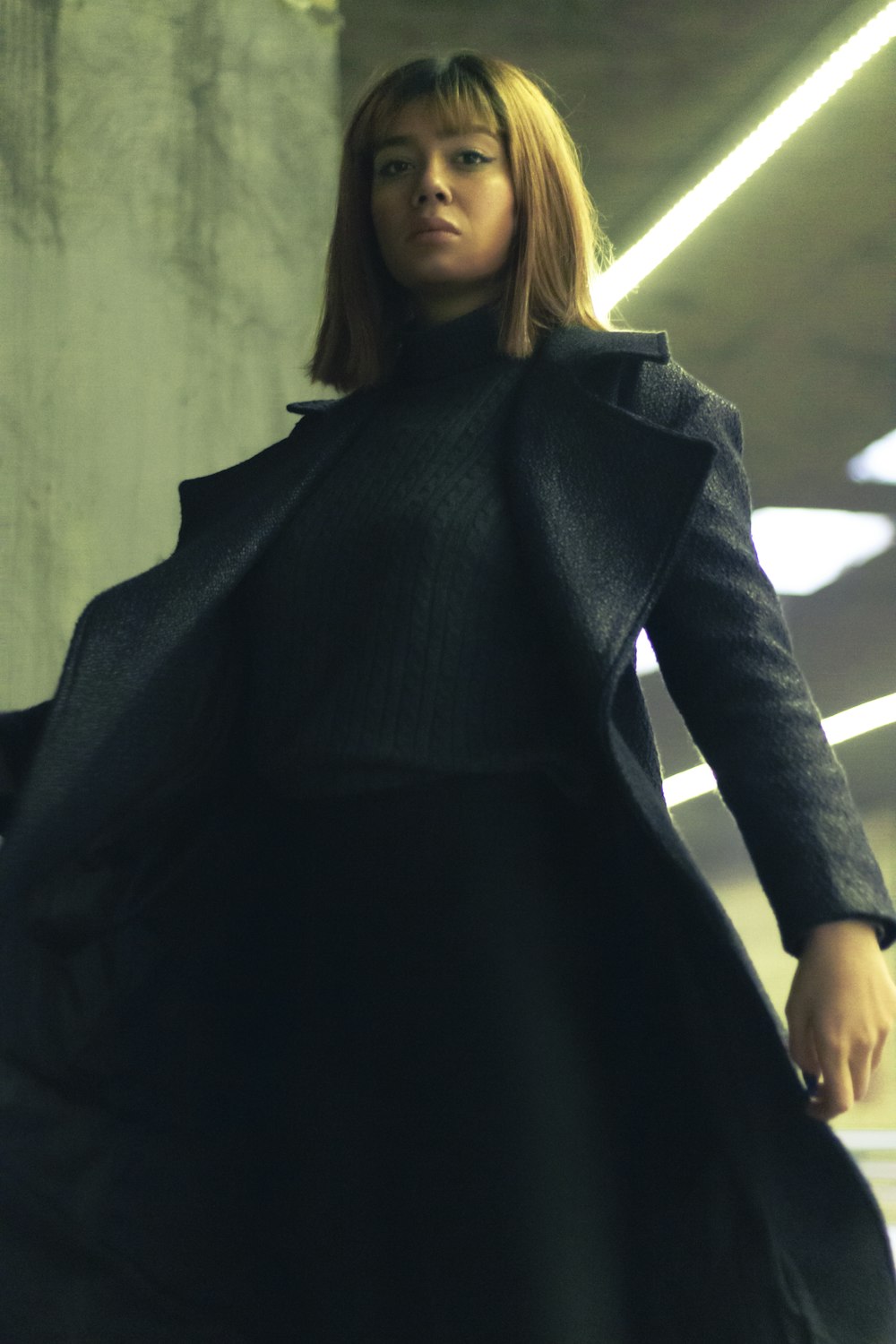 a woman in a black coat is walking