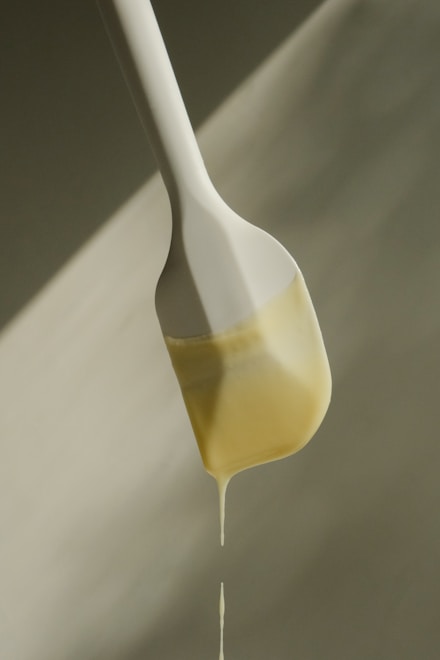 a spoon with liquid pouring thm friendly butter cream syrup from it