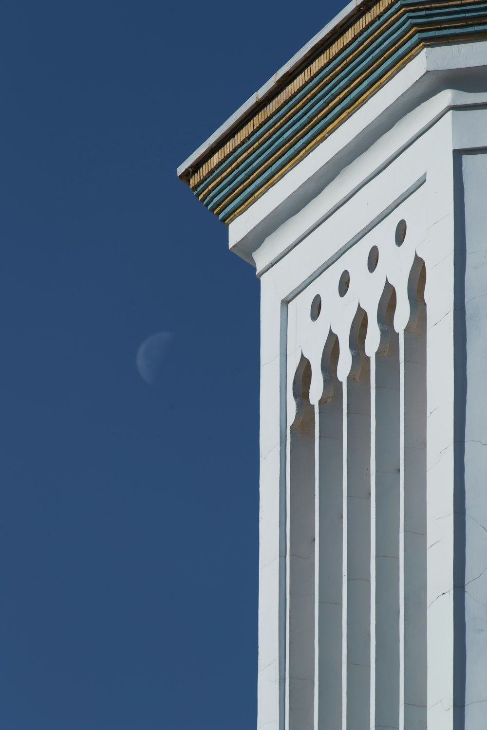 um edifício branco com um céu azul no fundo