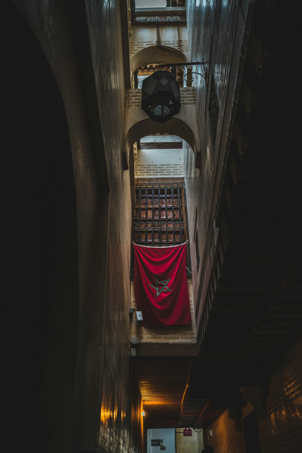 a narrow hallway with a red cloth hanging from the ceiling