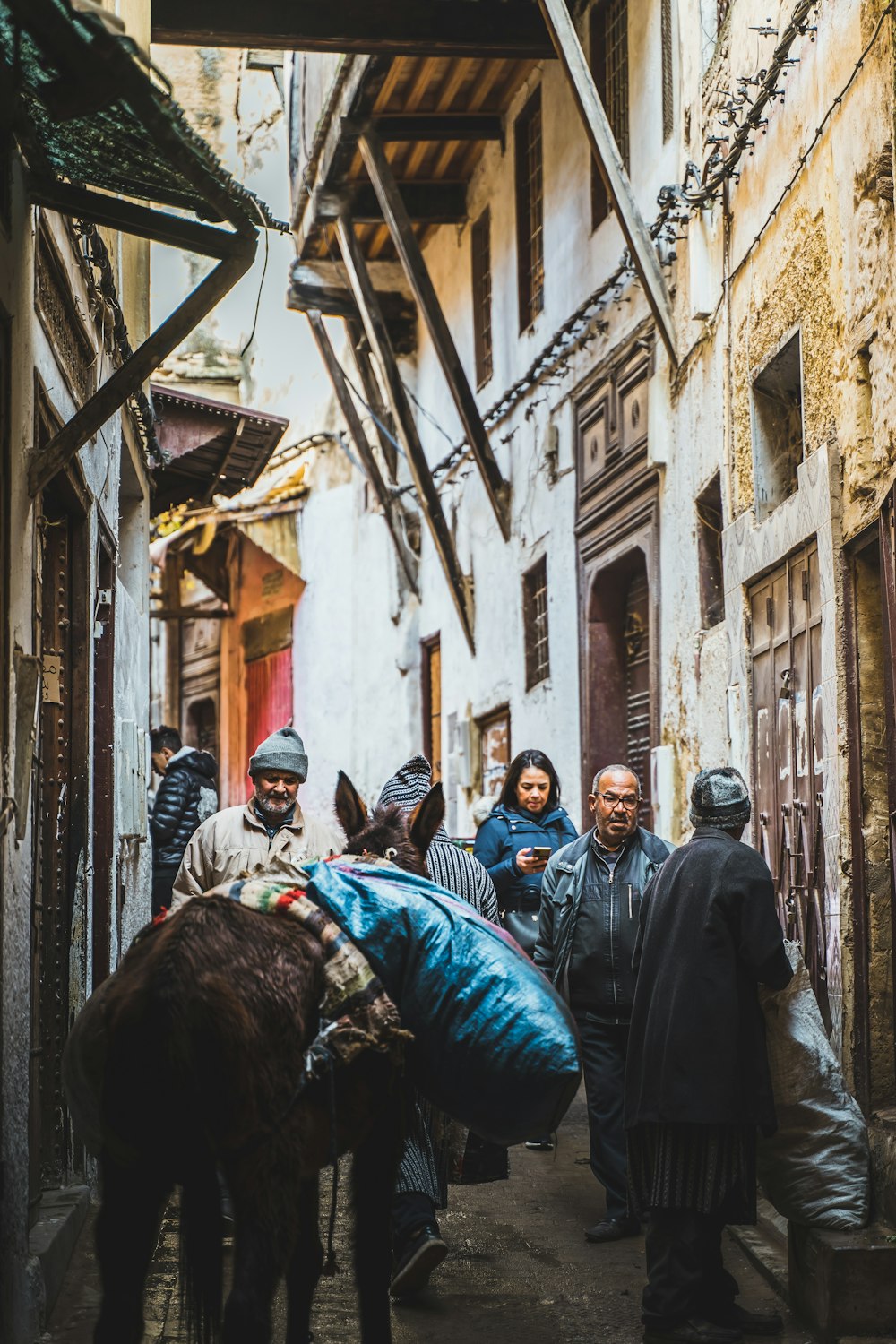 a group of people walking down a narrow street