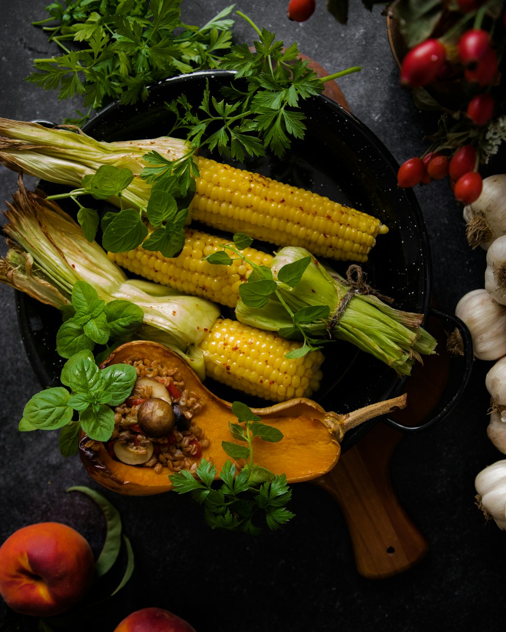 corn on the cob and vegetables on a table