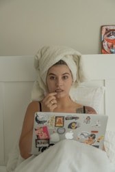 a woman with a towel on her head using a laptop