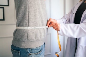 a woman measuring her waist with a measuring tape