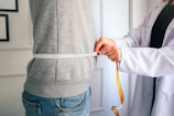 a woman measuring her waist with a measuring tape