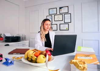 a woman sitting at a desk with a laptop in front of her
