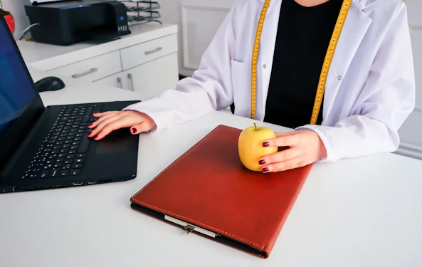 a woman sitting at a desk using a laptop computer