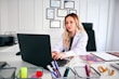 A smiling woman organizing medical documents and schedules at her desk.