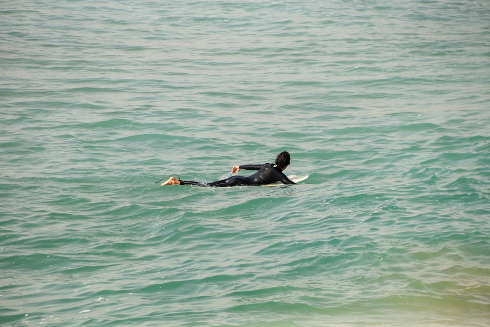 a person laying on a surfboard in the ocean