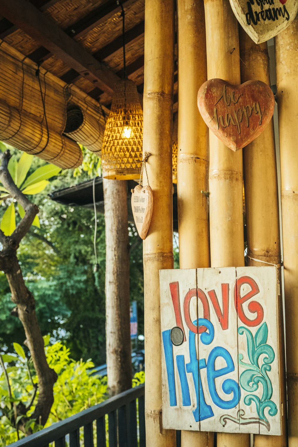 a sign that says love life hanging on a bamboo wall