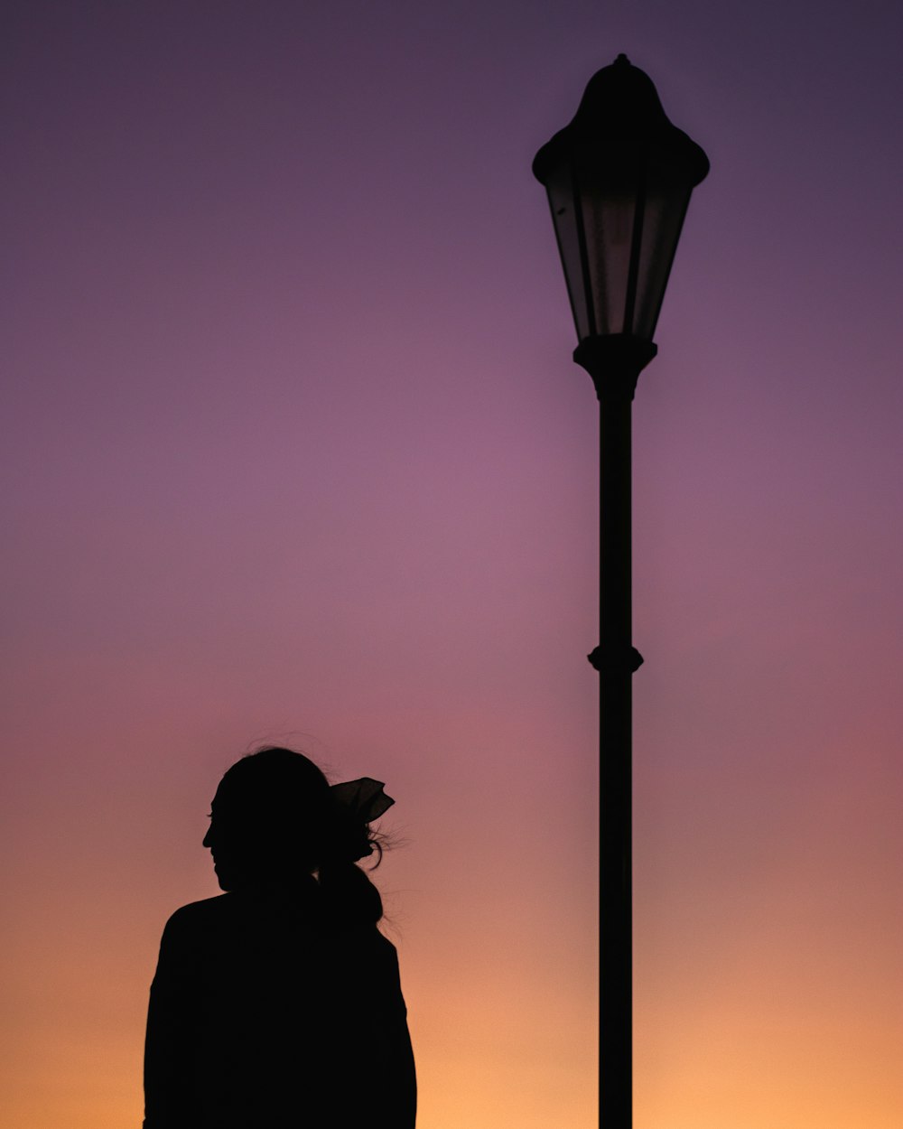 a person standing next to a street light