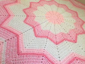 Close-up of a colorful crochet blanket featuring soft, textured stitches.