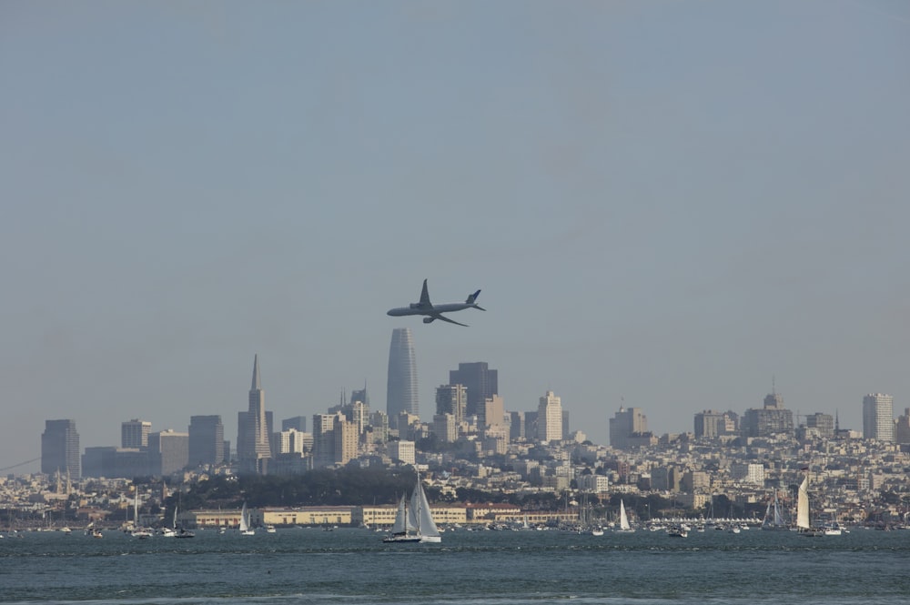 a large jetliner flying over the top of a city