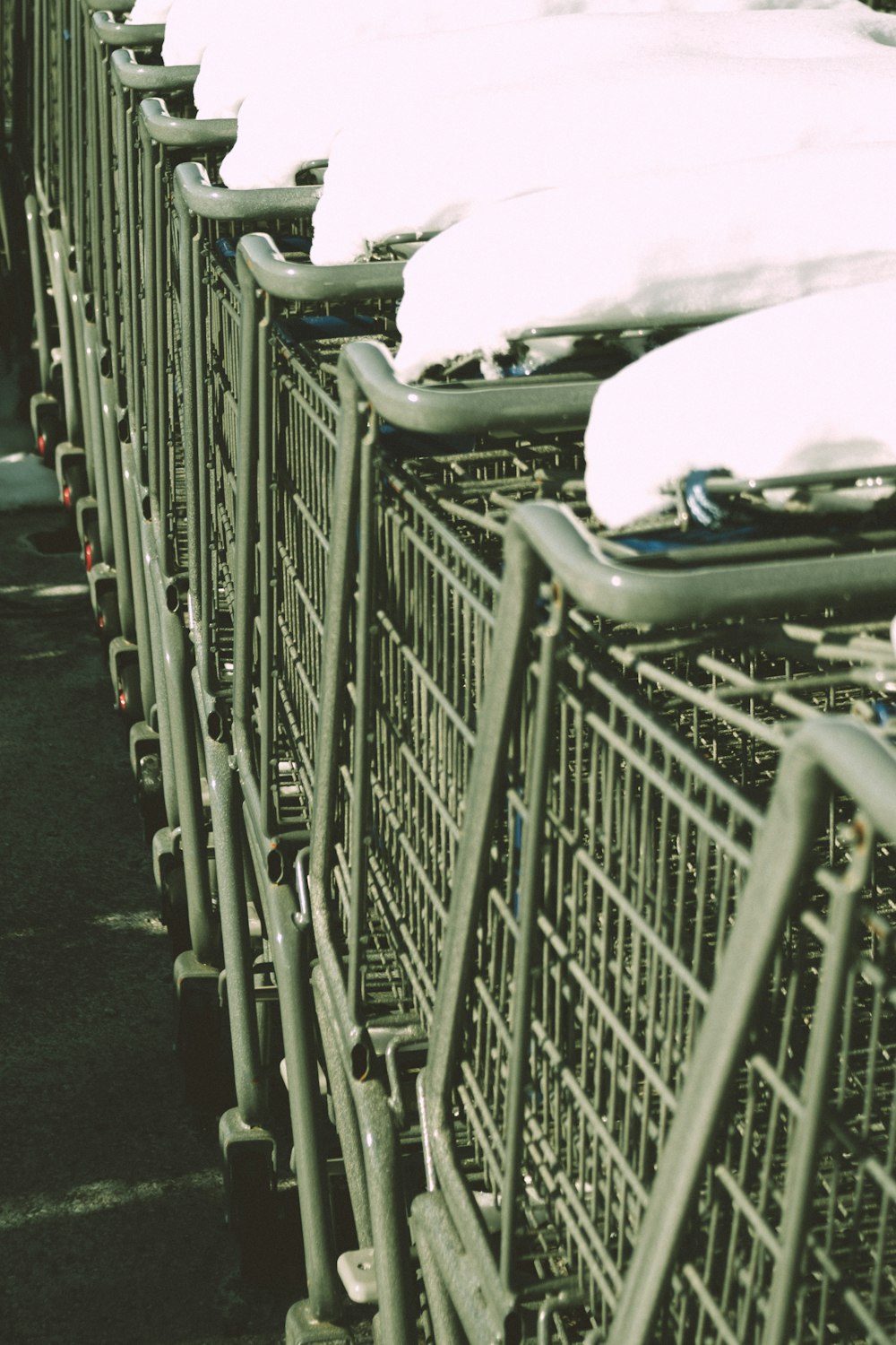 a row of shopping carts covered in snow