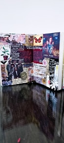 An open sticker-book journal with handwritten notes and vibrant stickers scattered around.