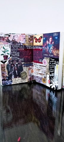 An open sticker-book journal with handwritten notes and vibrant stickers scattered around.