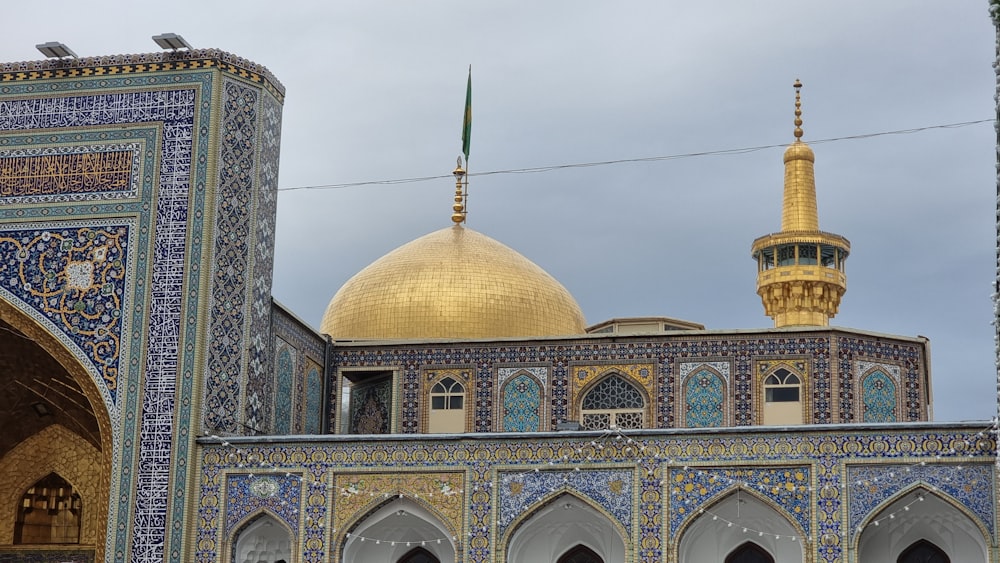 an ornate building with a gold dome and blue tiles