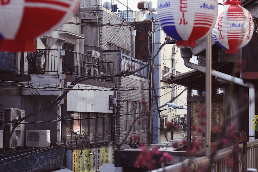 a bunch of red, white and blue paper lanterns hanging from a wire