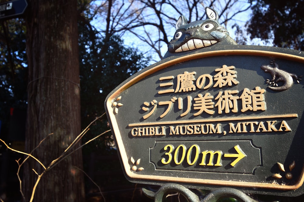 a sign with a dragon on it in a park