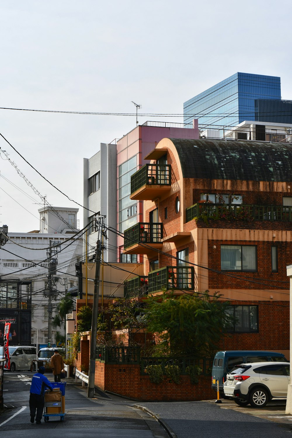 a couple of people walking down a street next to a tall building