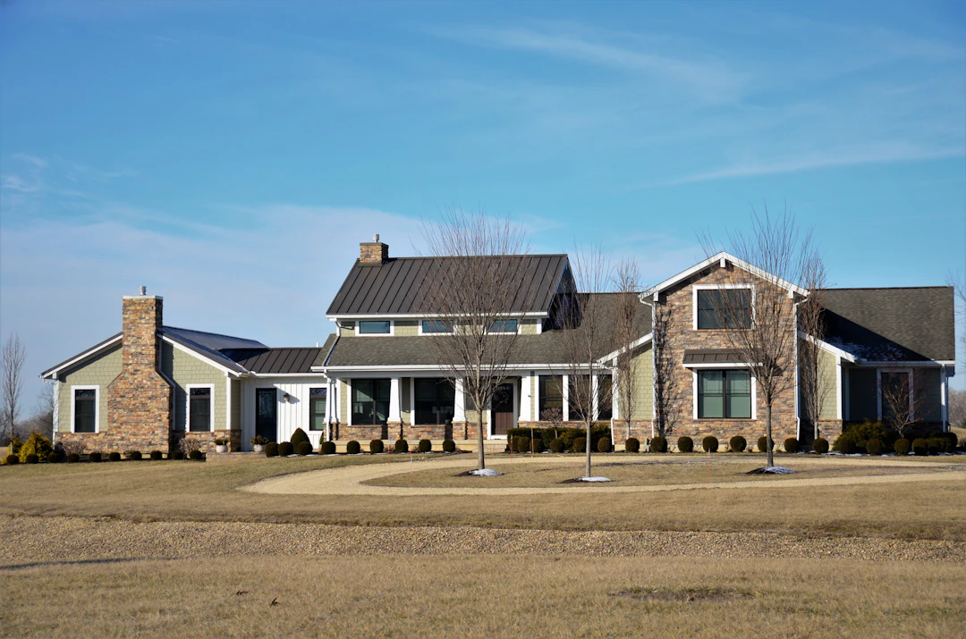 Large home with many windows set on a wide, open lawn