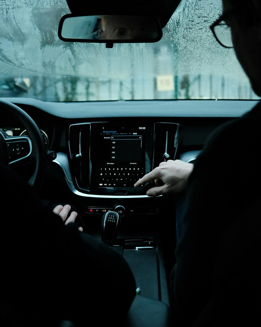 a person sitting in a car with their hands on the steering wheel