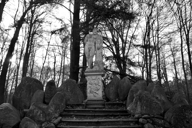 a statue sitting in the middle of a forest