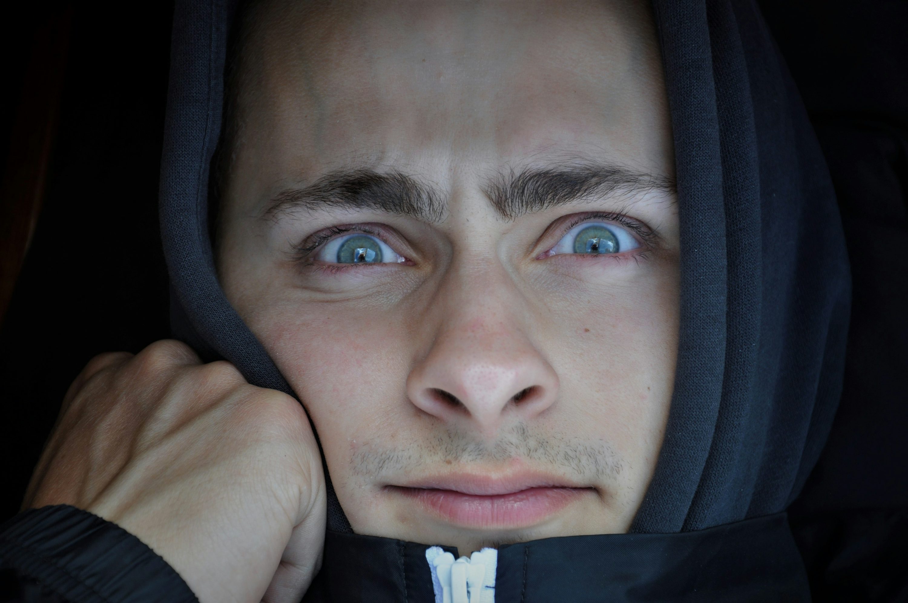 a man in a hoodie with blue eyes