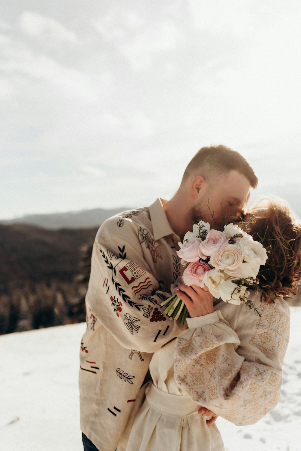 a man and a woman embracing in the snow