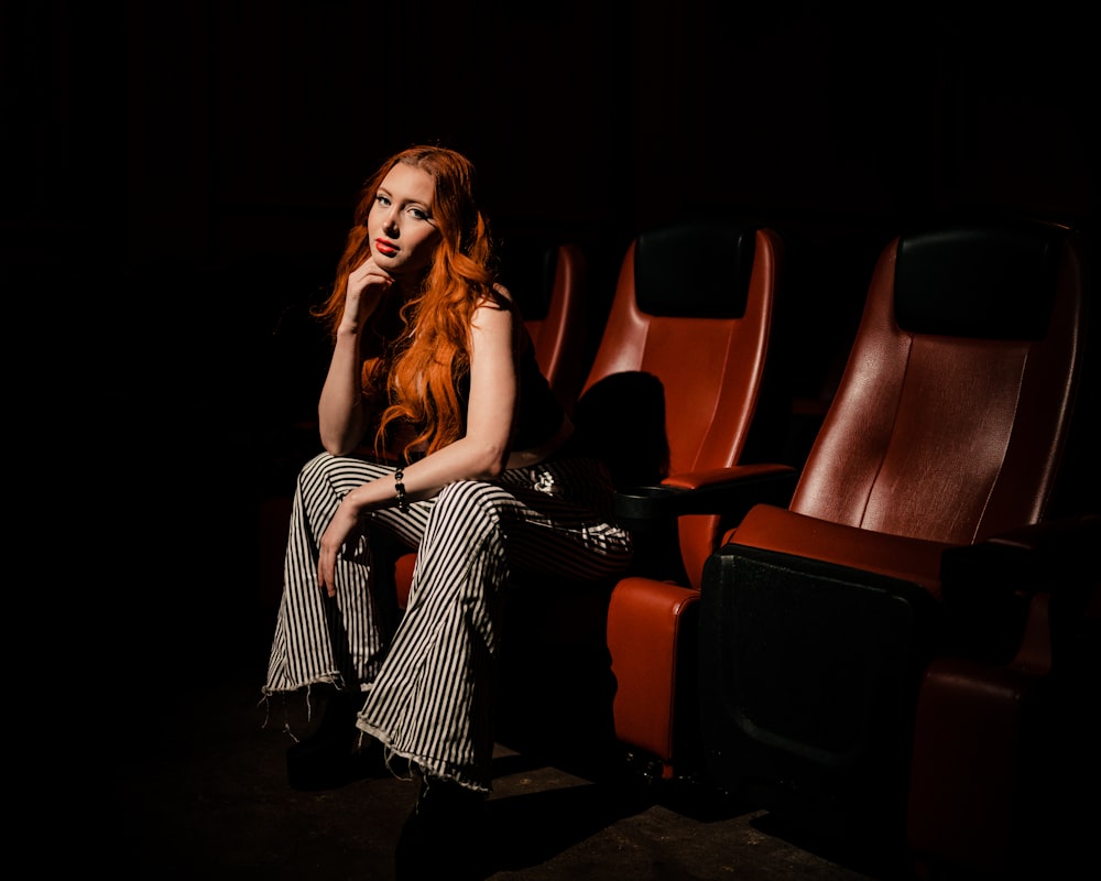a woman with red hair sitting in a theater