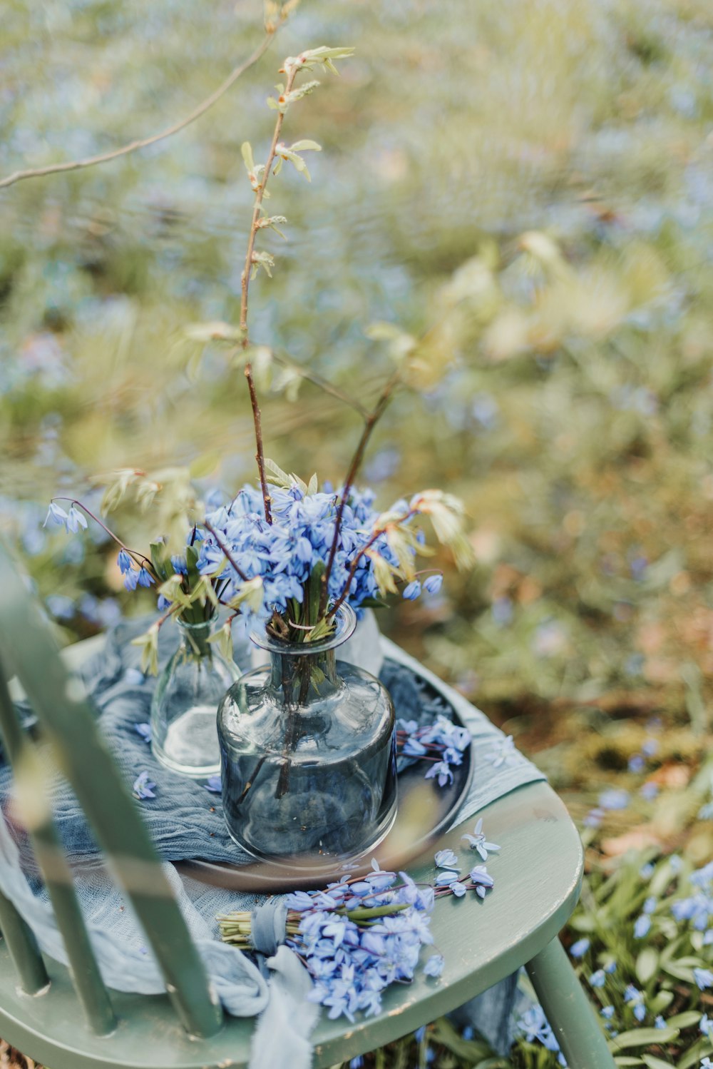 a glass vase filled with blue flowers sitting on top of a table