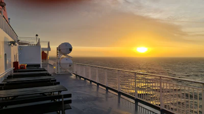 A tranquil ocean sunset viewed from the deck of a luxury cruise ship.