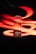 A can of Bira 91 beer is prominently displayed against a black background, with dynamic red light streaks swirling around it. The can features branding and symbols including a dragon and the word 'FEST' in bold lettering, indicating an Oktoberfest Lager edition.