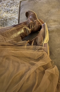 Elegant leather boots displayed on a rustic wooden surface.