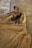 A pair of elegant heeled boots displayed on a wooden floor, surrounded by soft winter fabrics.