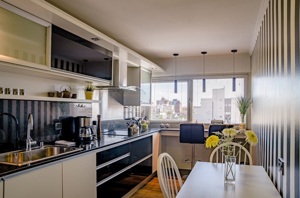 a kitchen with a table and chairs next to a window