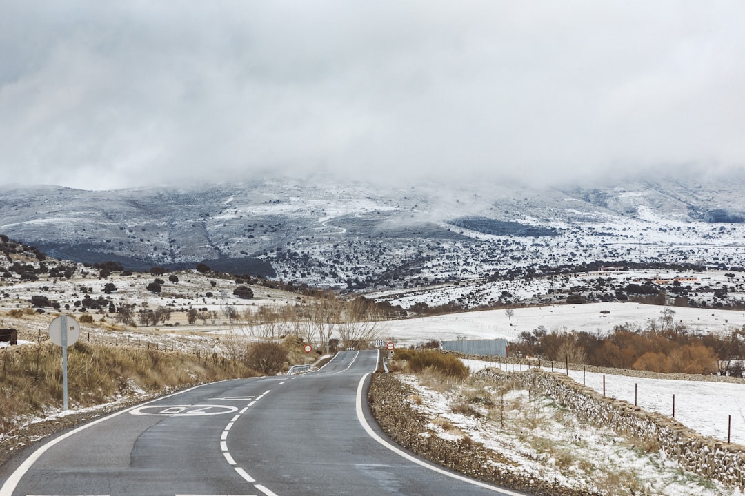 a road in the middle of a snowy landscape, Provincial asphalt road in the countryside against the backdrop of mountains 