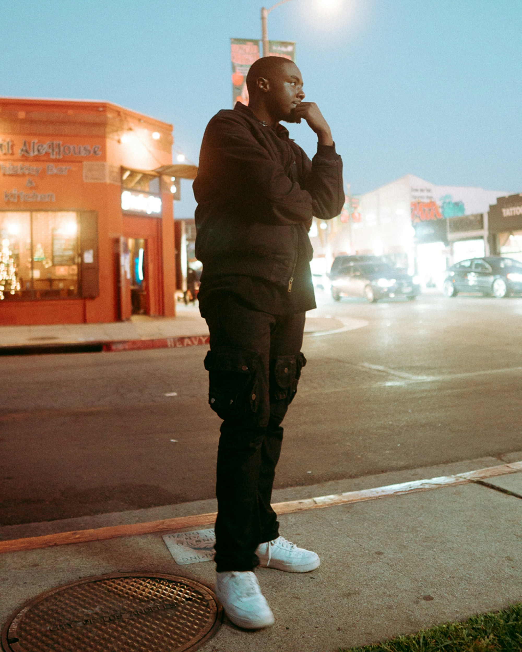 a man standing on a sidewalk talking on a cell phone